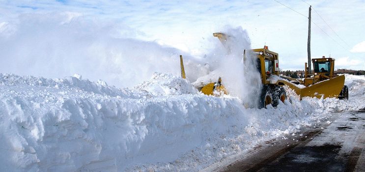 Snow removal equipment plowing snow