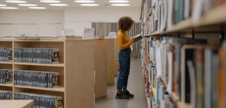 Woman standing among shelves of books