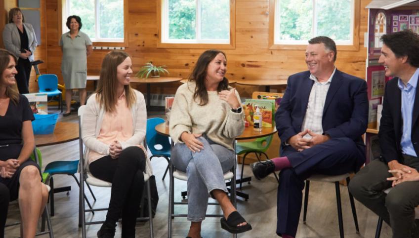 image of five adults sitting on chairs in a daycare centre
