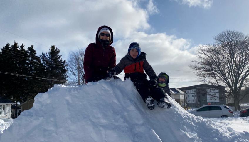 image of three people on top of a small snow drift