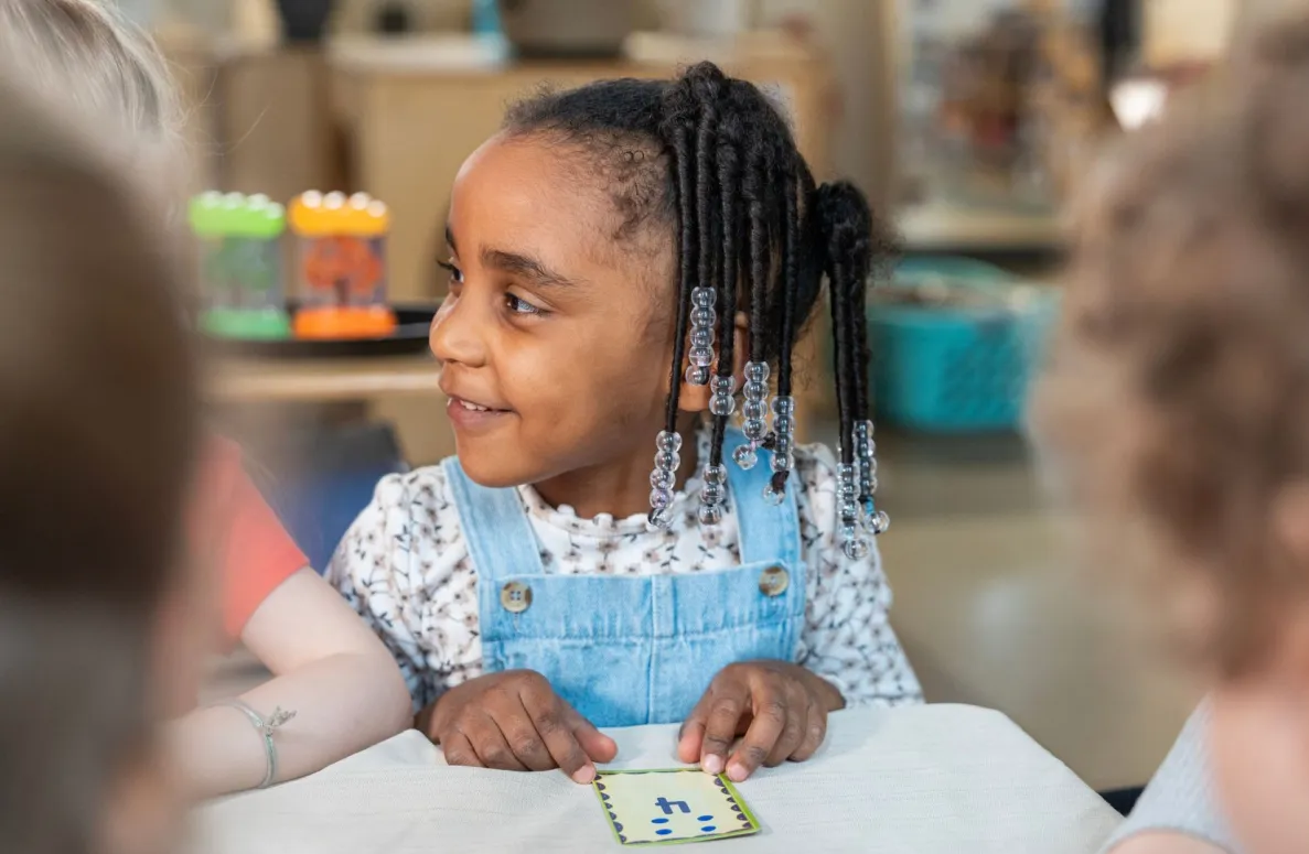 Un gros plan d&#039;une jeune fille noire avec des perles dans les cheveux.