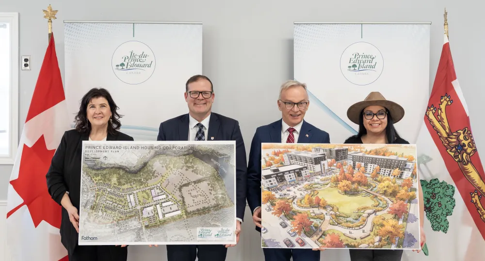 Four people stand together holding diagrams of the future development.