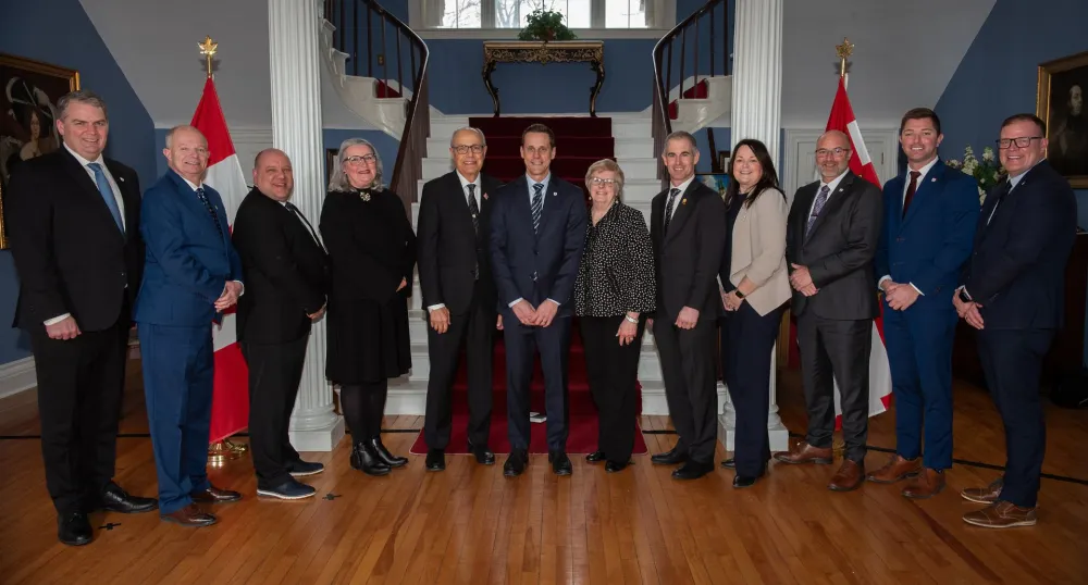 The premier and the ministers stand together at Government House.