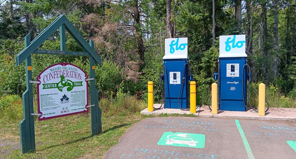 Two EV charging stations beside a Confederation Trail sign.