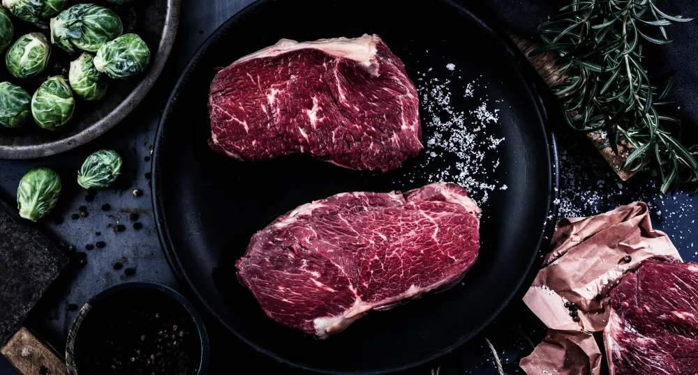 Cuts of steak in a cast iron pan.