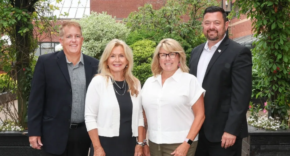 Four people standing and smiling