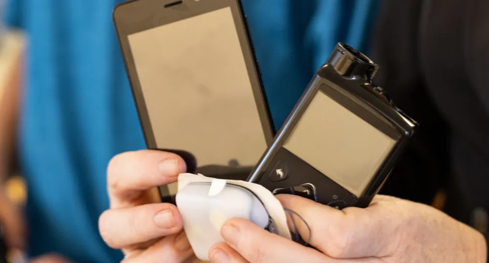 A person holds an insulin pump in their hands.
