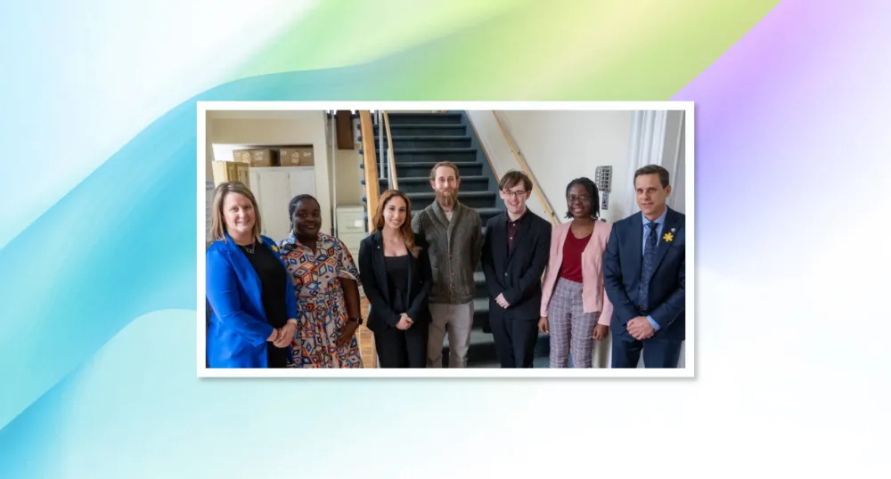 image of people standing shoulder to shoulder in a building at the bottom of stairs
