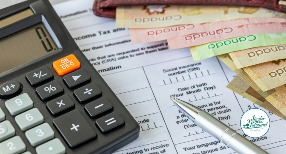A calculator and colorful Canadian bills sit on a tax document.