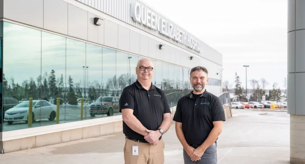 Two men stand outside the Queen Elizabeth Hospital.