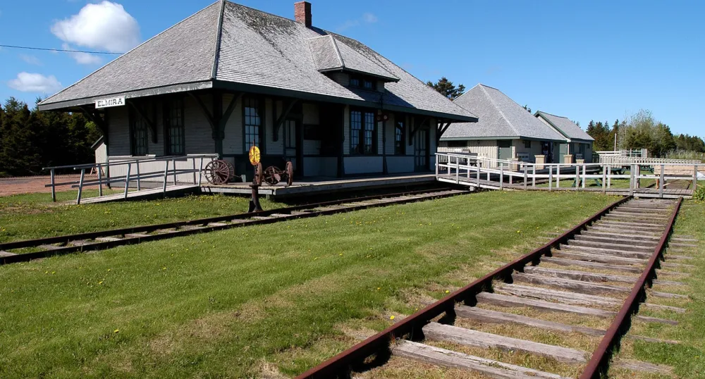 Gare d'Elmira et une vieille voie ferrée par une journée ensoleillée et au ciel bleu.