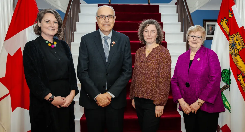 Four people stand next to each other.