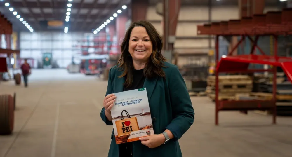 Minister Jill Burridge holding a copy of the 2026-2026 Operating Budget