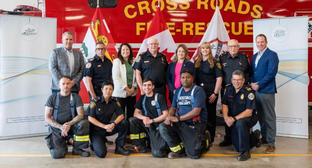 Les ministres et les pompiers posent devant un camion de pompiers.