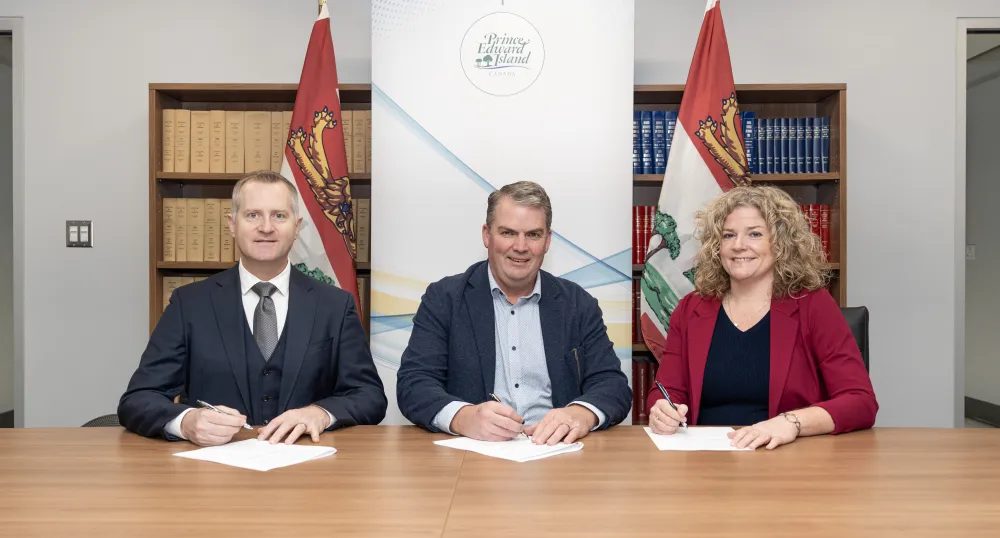 Three people sit next to each other at a table.