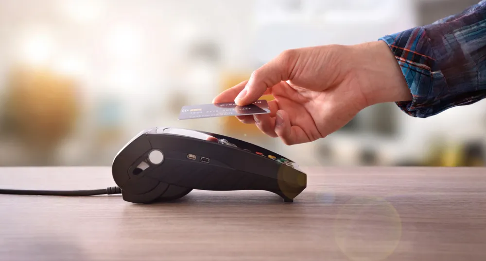 Image of customer using debit maching at retailer who sells vaping products