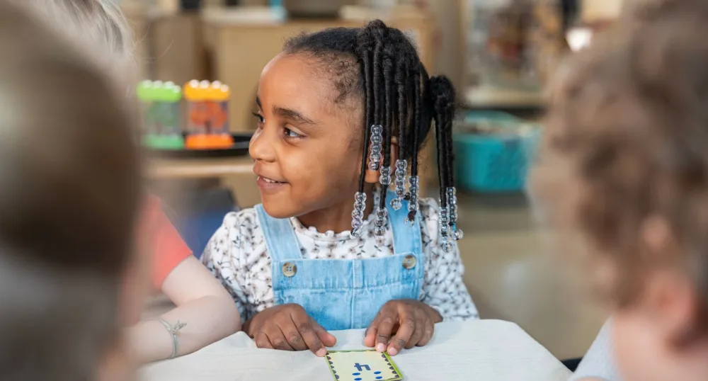 Un gros plan d'une jeune fille noire avec des perles dans les cheveux.