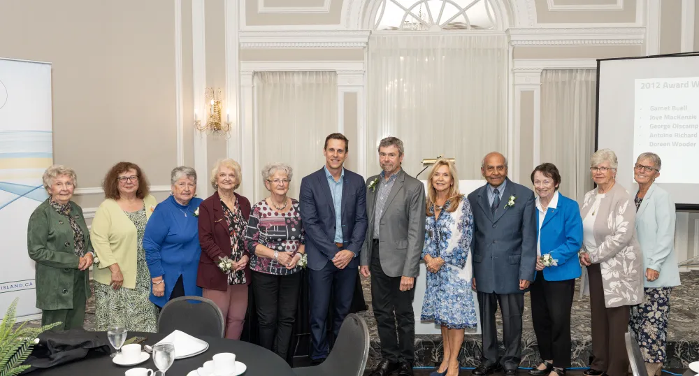 The premier, minister and 10 award recipients stand together.