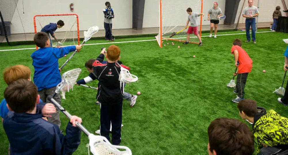 Group of school children learning to play lacrosse