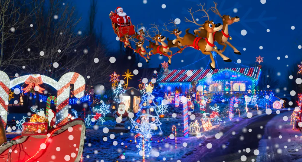 Santa in his sleigh flying over a Christmas decorated house