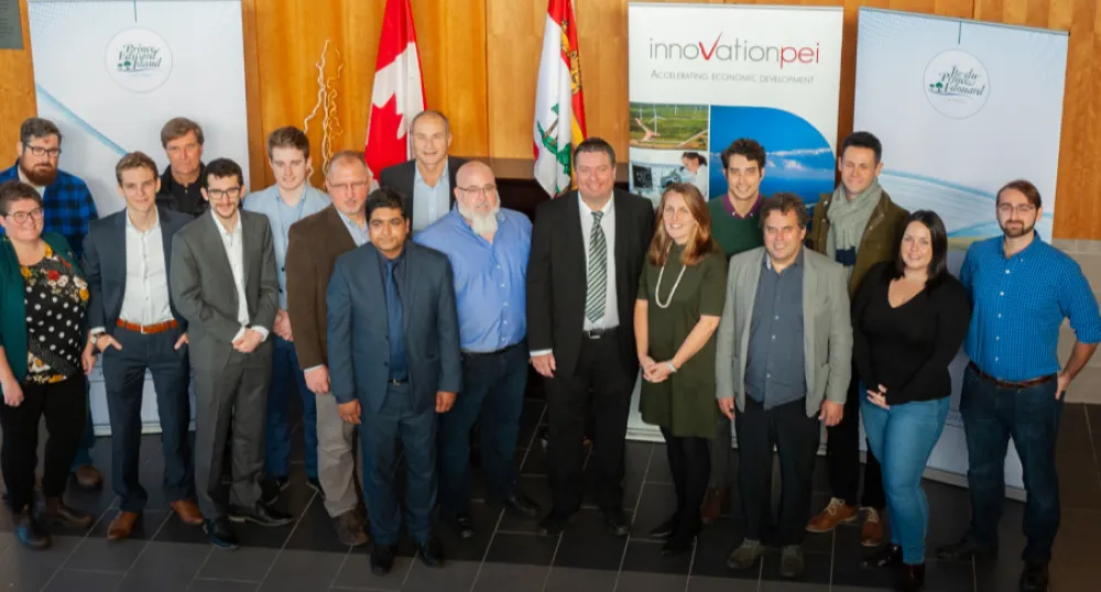 a group of people standing shoulder to shoulder in front of of a classroom board