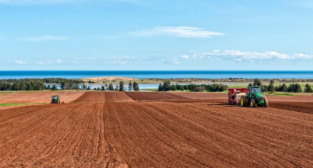 image of  two tractors plowing a field