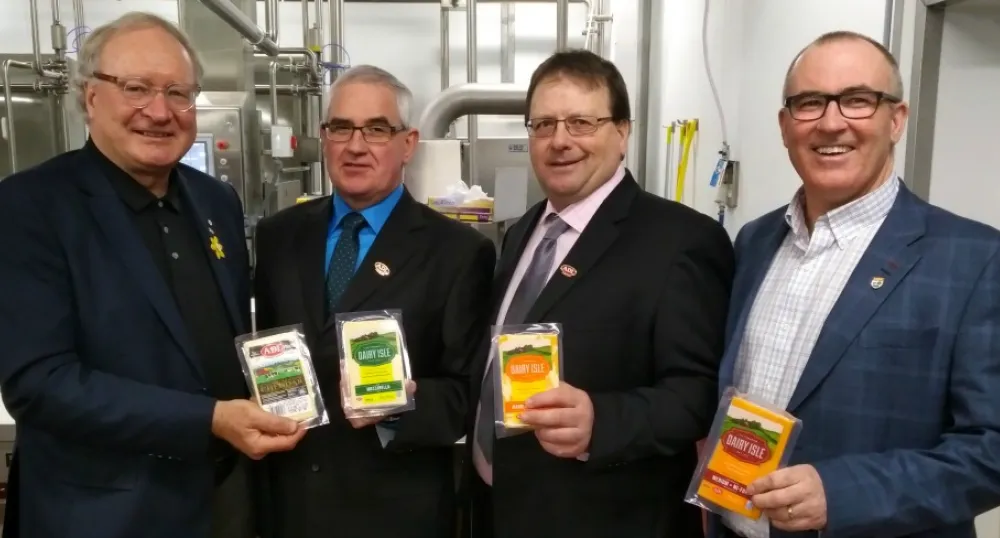 Photo shows four men holding packaged ADL cheese products