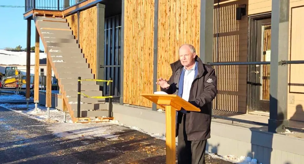 image of a person speaking at a podium outside a building