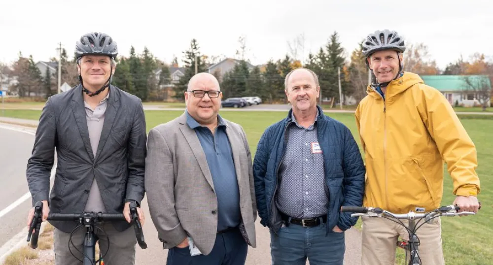 Image of two people on bicycles beside two other people at a park