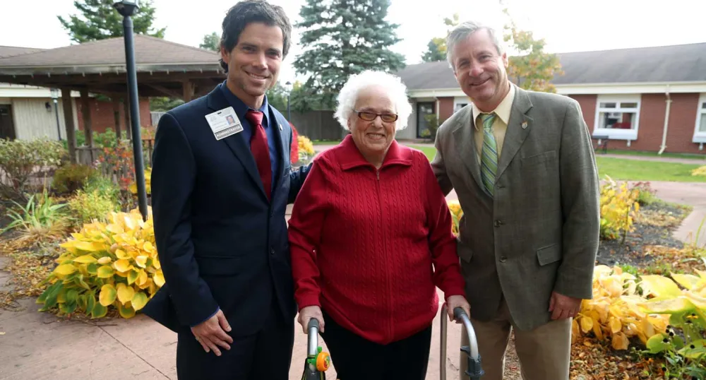 Minister Robert Henderson and two others standing in front of Beach Grove Home