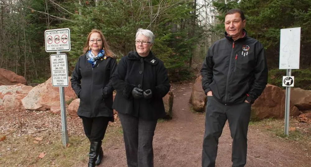 Minister Biggar and two other people walking near newly neamed trail in Bonshaw.