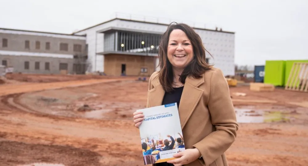 image d&#039;une personne tenant un document alors qu&#039;elle se tient devant un immeuble en construction