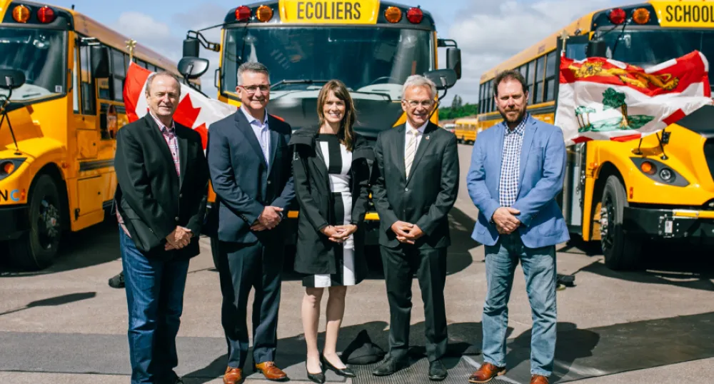 image of people standing in front of electric buses