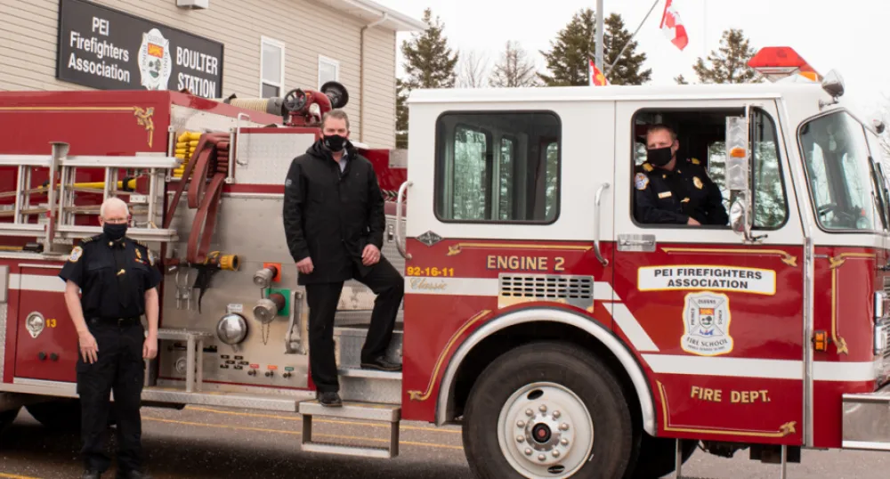 image of three people standing on a fire truck