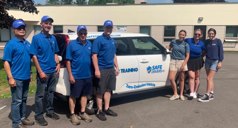 image of people standing in front of a new electric vehicle with a building in the background