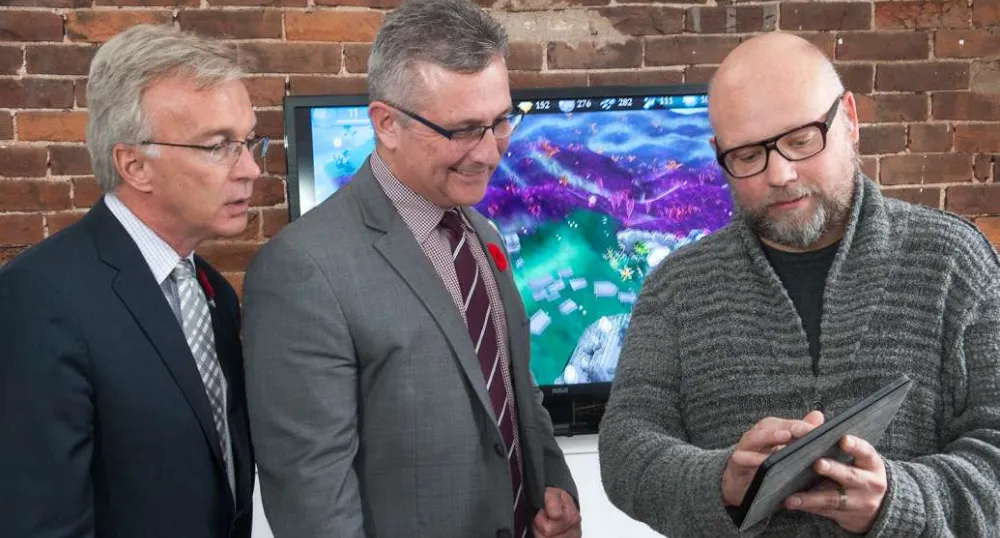Minister MacDonald and  MP Sean Casey look at tablet heald by icejam founder Stu Duncan