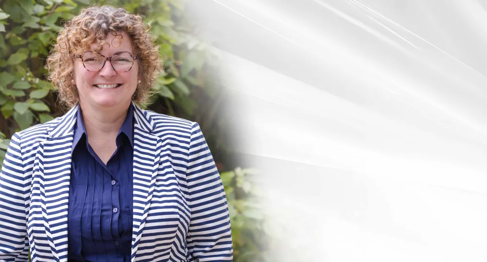 image en gros plan d’une personne debout devant un arbre feuillu