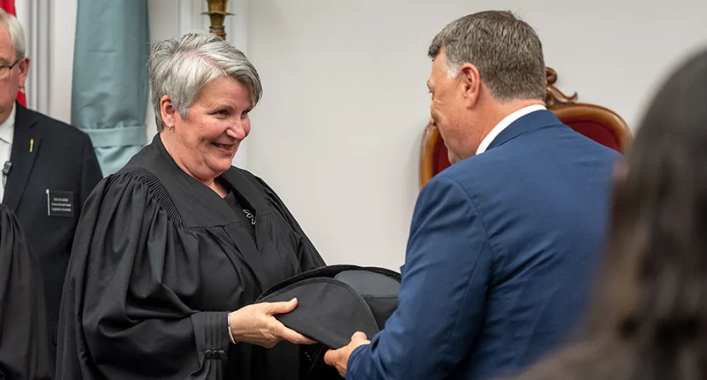 image d&#039;une personne remettant à une autre personne un chapeau de président officiel