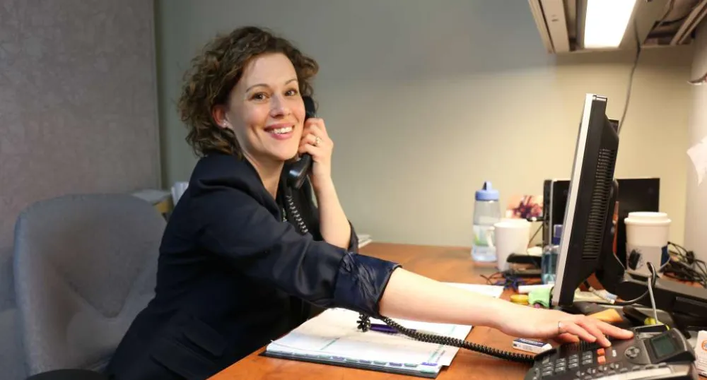Mary Laura Coady speaks on her telephone while sitting at her desk