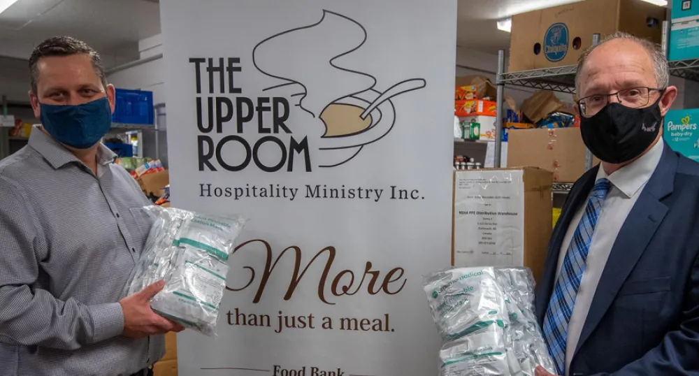 image  of 2 people with masks on standing in front of a sign