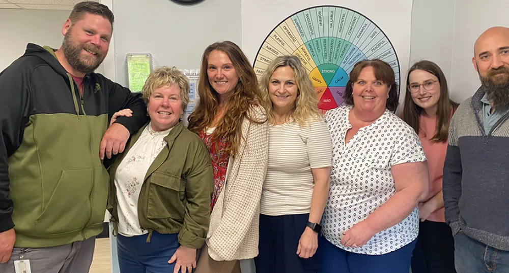 Un groupe de personnes se tient côte à côte en souriant