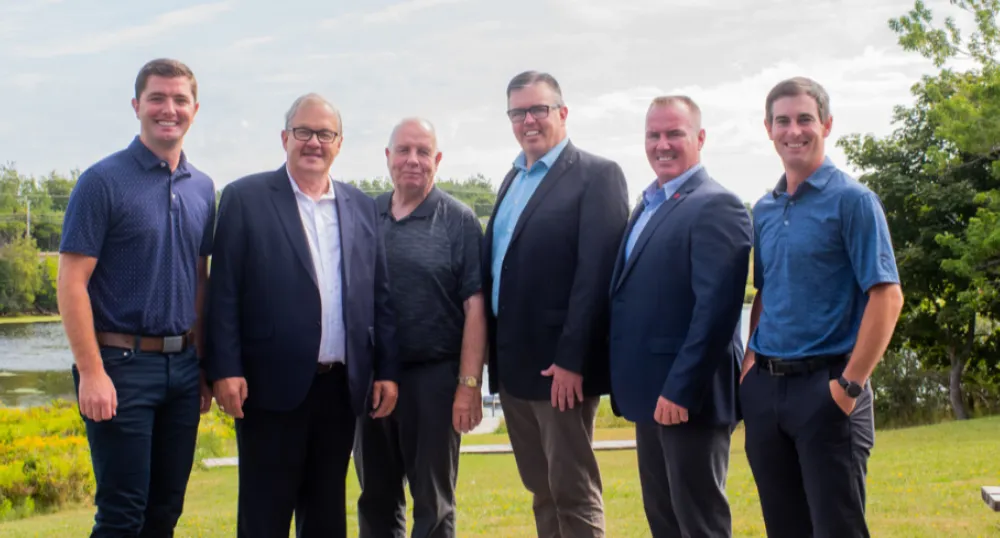 Six men stand on the bank of the Morell river following a federal provincial funding announcement