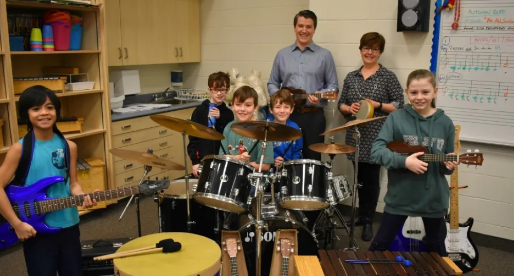 Minister Jordan Brown with music teacher Ellen Davis and students at Stratford Elementary School