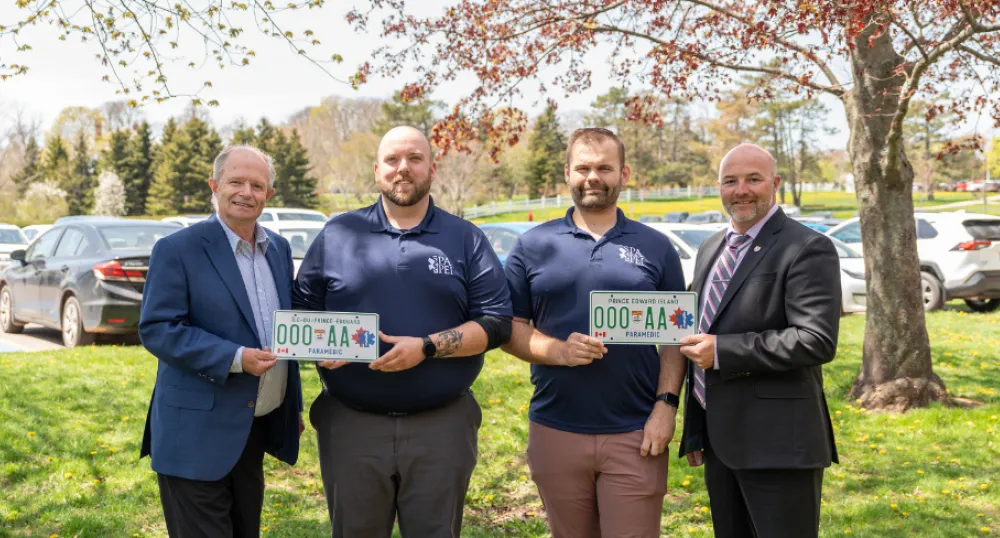 photo of four people, with license plates 