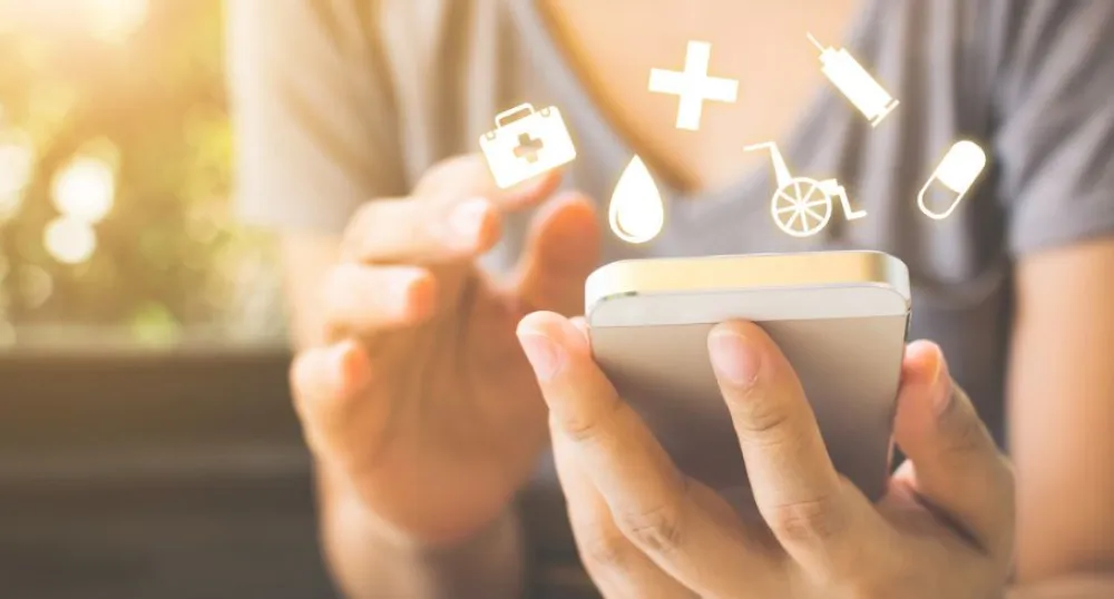 Women holding cellphone with medical symbols floating in air