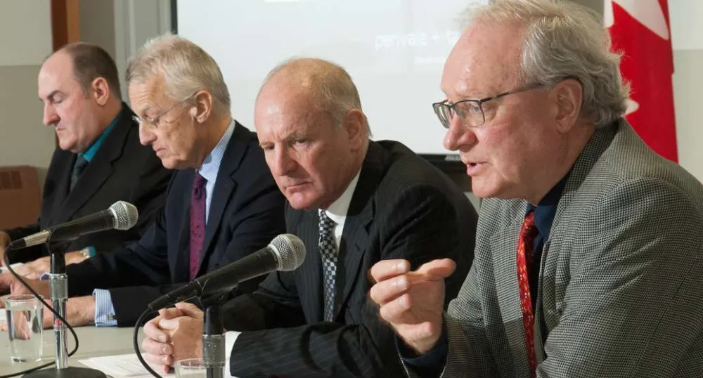 Premier MacLauchlan and three others sit at a table discussing the review