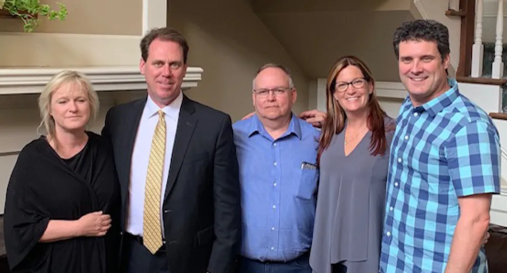 Five people standing shoulder to shoulder