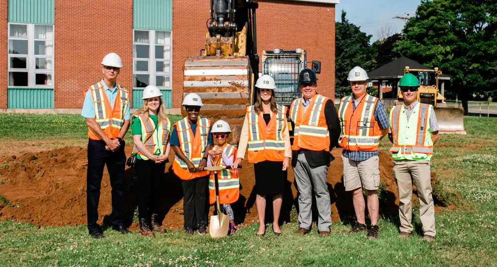 image of people standing shoulder to shoulder in front of a school