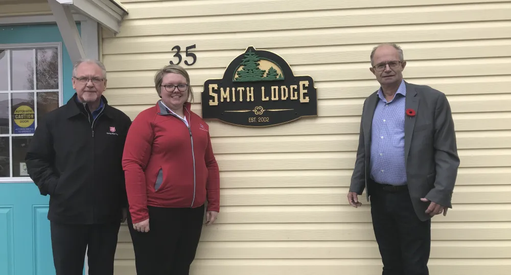 Image of three people standing in front of a building
