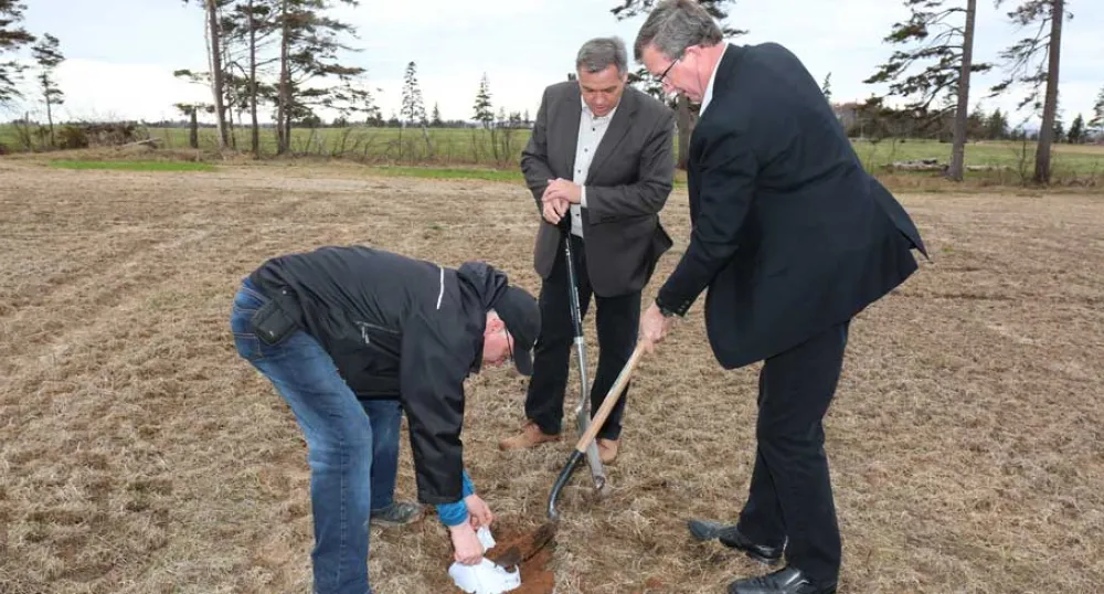 Environment Minister Robert Mitchell and Agriculture Minister Alan McIsaac bury a pair of white cotton brief to test the quality of Island soil